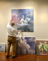 Ozols hanging his exhibition at The Academy Gallery in 2017